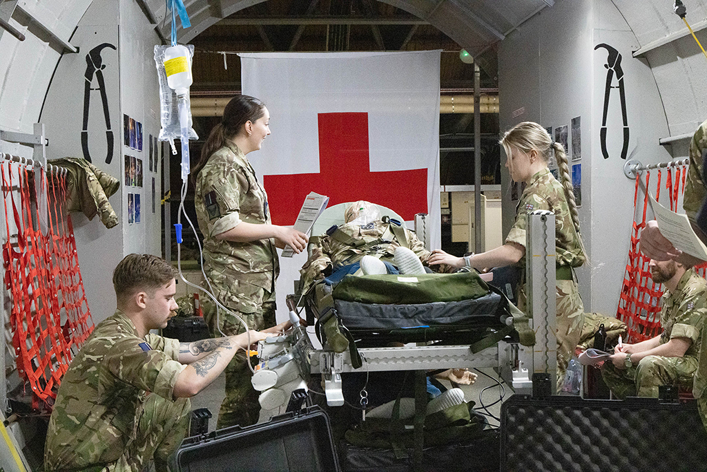 A Tactical Medical Wing team attend to the needs of a training patient in a mock-up of an aircraft cargo bay in medevac role